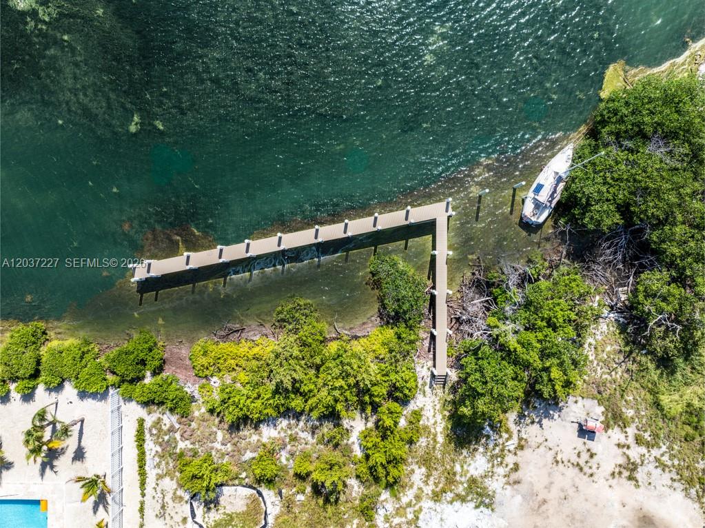 An aerial view shows a wooden dock extending into the water near a small boat — 30988 Witters Ln, Big Pine FL 33043, BIG PINE, FL