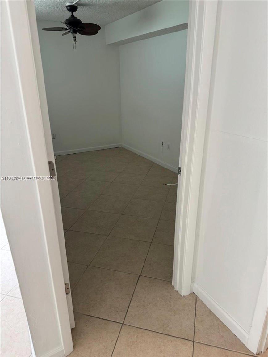 A small, empty room with light-colored tile flooring and a ceiling fan — 20850 San Simeon Way # 5, Miami FL 33179, MIAMI, FL