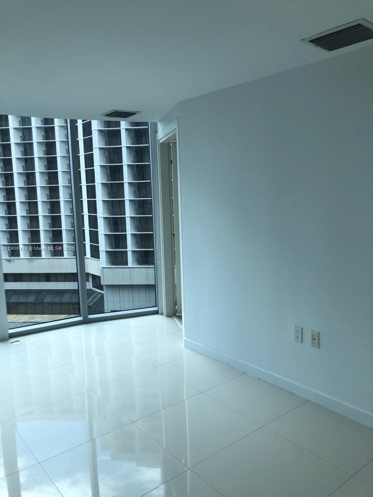 An empty room with white tile floors, white walls, and floor-to-ceiling windows — 200 Biscayne Boulevard Way # 902, Miami FL 33131, MIAMI, FL