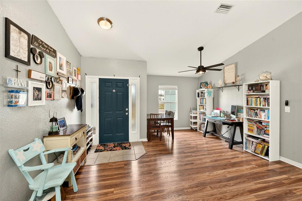A light green house exterior features a coral front door and two white columns — 2624 SHALIMAR TERRACE, NORTH PORT, FL