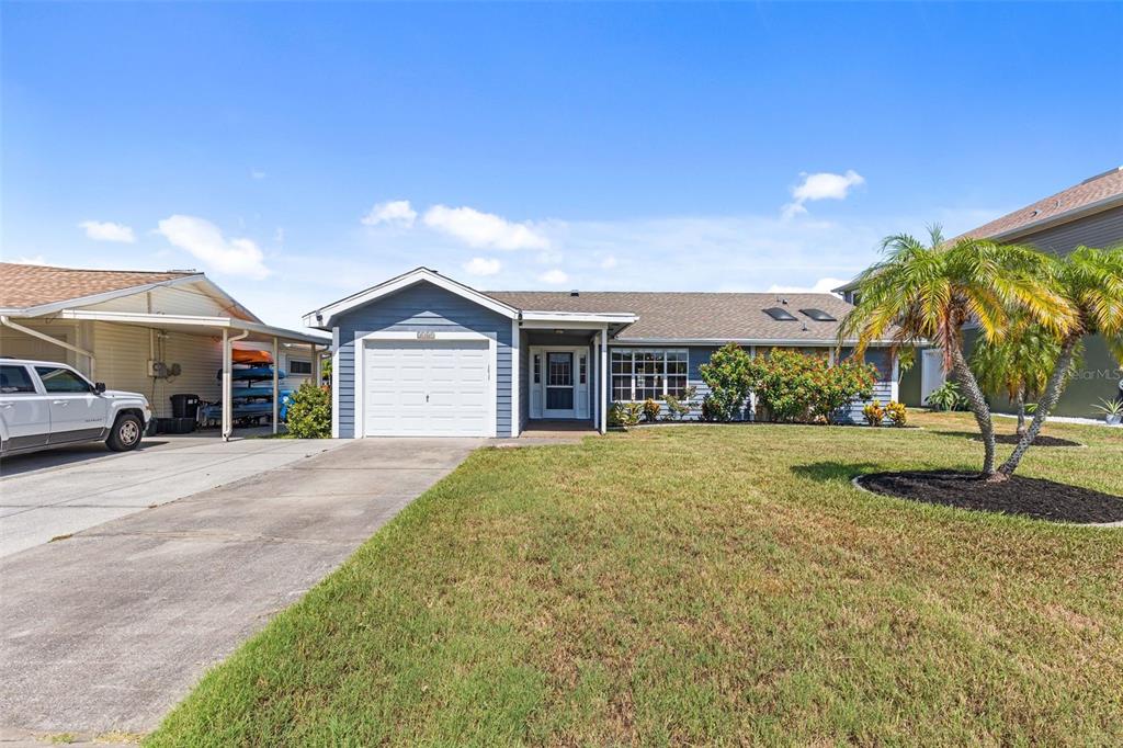 A single-story house with a blue exterior, a one-car garage, and a front lawn — 3345 POINSETTIA DRIVE, HERNANDO BEACH, FL