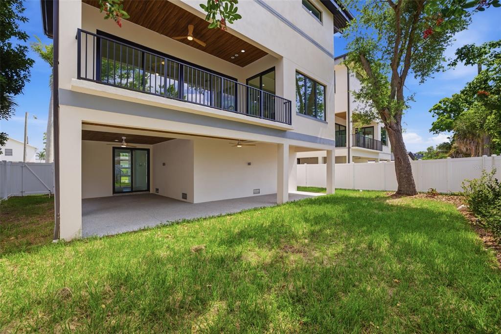 A modern living room features a light sofa, dark coffee table, and large sliding glass doors — 1943 SHORE ACRES BOULEVARD NE, ST PETERSBURG, FL