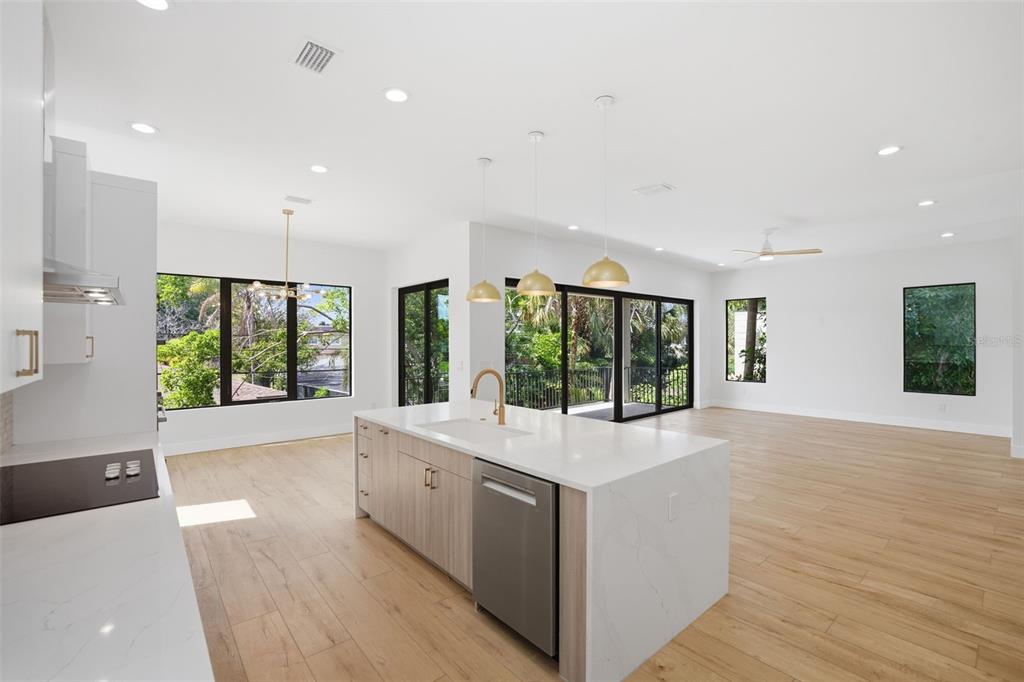 A modern kitchen features white upper cabinets, wood-grain lower cabinets, a large island, and stainless appliances — 1943 SHORE ACRES BOULEVARD NE, ST PETERSBURG, FL