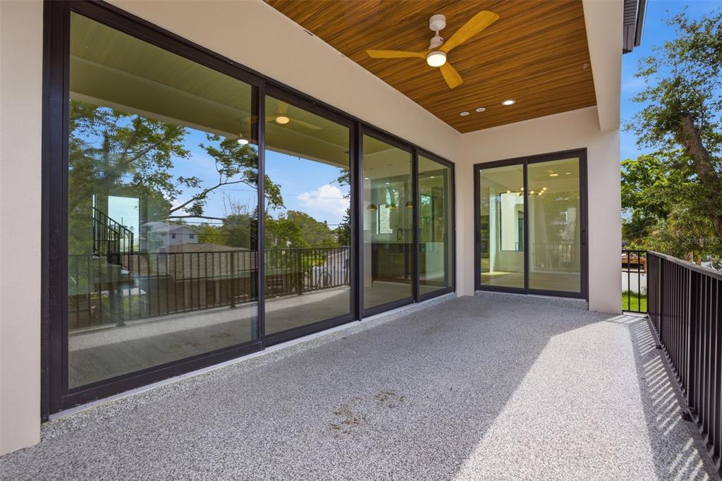 A two-story house with a covered ground-level patio, a second-floor balcony, and a grassy backyard — 1943 SHORE ACRES BOULEVARD NE, ST PETERSBURG, FL