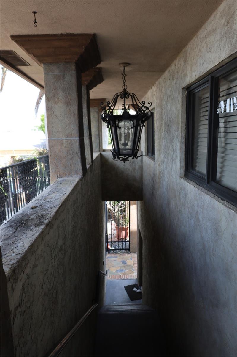 A view looking down a stucco-walled outdoor staircase featuring a hanging wrought iron lantern — 340 Conniston Rd # 340, West Palm Beach FL 33405, WEST PALM BEACH, FL