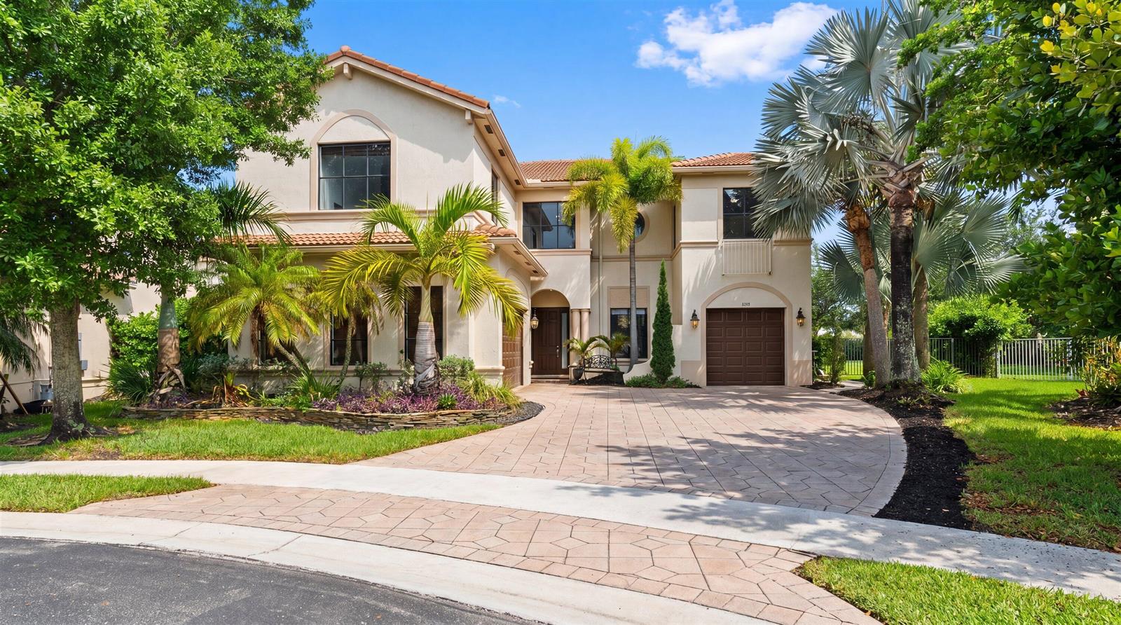A two-story stucco house with a tile roof, palm trees, and a paved driveway — 1215 Creekside Drive, Wellington FL 33414, WELLINGTON, FL