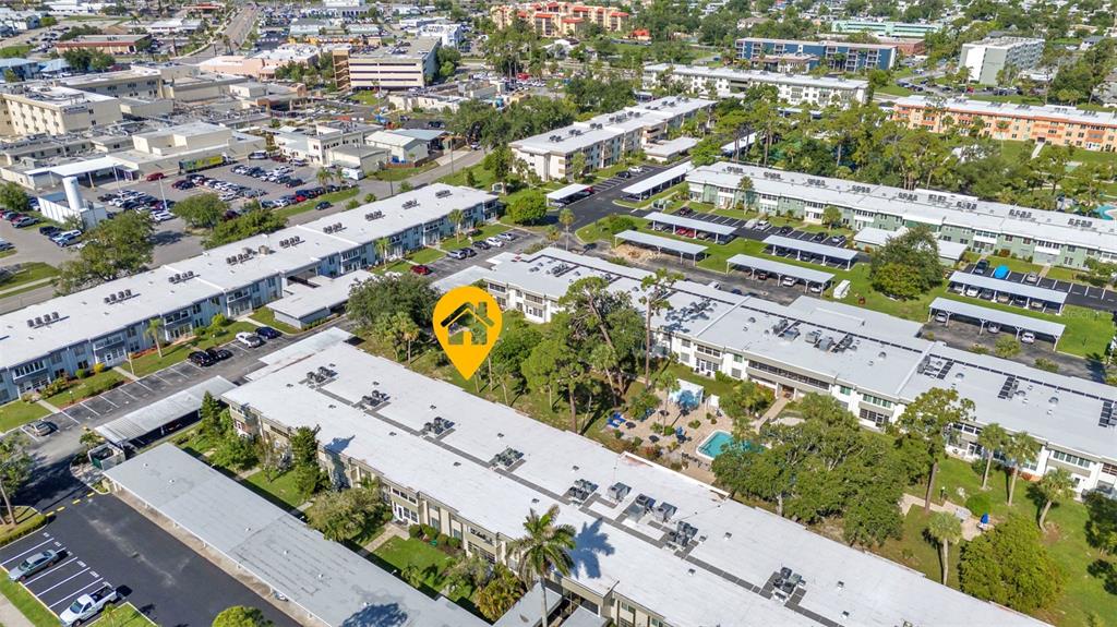 An aerial view shows multiple apartment buildings with flat roofs and parking lots — 2437 HARBOR BOULEVARD UNIT 114, PORT CHARLOTTE, FL
