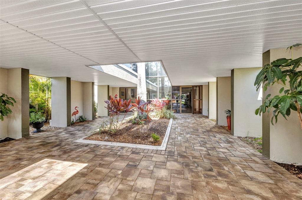 A covered entryway features a central garden bed under a skylight and paver flooring — 2437 HARBOR BOULEVARD UNIT 114, PORT CHARLOTTE, FL