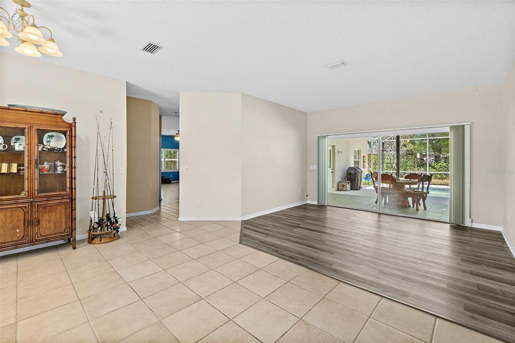 A room with tile and wood-look flooring features a large sliding glass door to a patio — 28 MONTAUK LANE, PALM COAST, FL