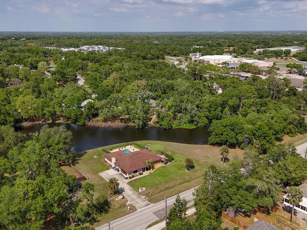 An aerial view shows a house with a pool situated next to a pond — 3927 DESOTO ROAD, SARASOTA, FL