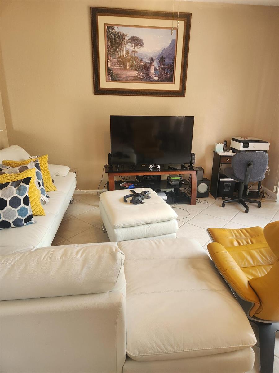 A living room features a white sectional sofa, a television on a stand, and artwork — 5148 S Aurora Lake Circle, FL 33463, FL