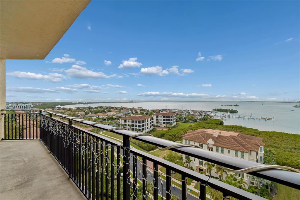 A balcony with a black metal railing overlooks a coastal residential area and the water — 5823 BOWEN DANIEL DRIVE UNIT 1103, TAMPA, FL
