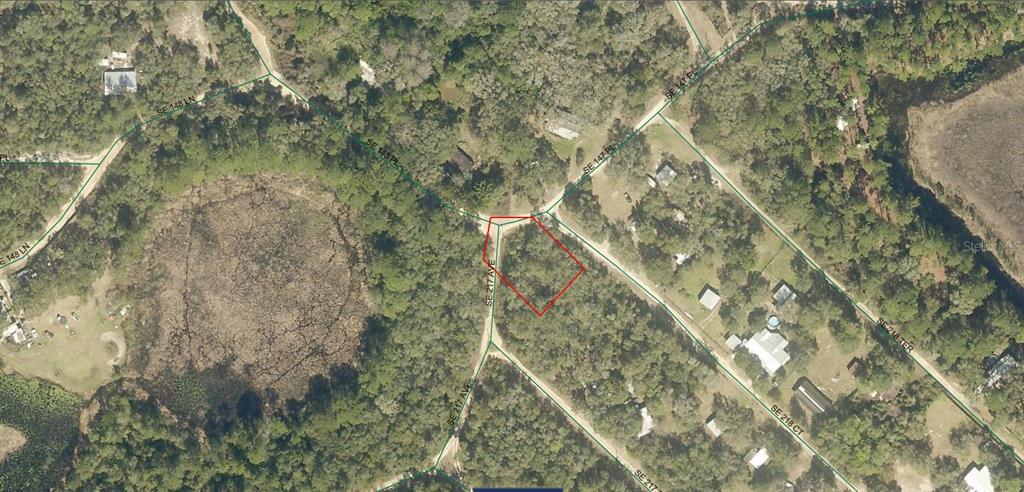 An aerial map view shows a vacant, wooded lot outlined in red at a road intersection — 5075-042-034 SE 217TH AVENUE, UMATILLA, FL