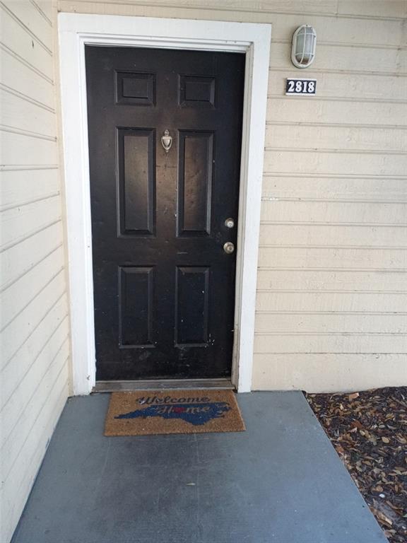 A black front door with a door knocker sits on a concrete porch — 1037 S HIAWASSEE ROAD UNIT 2818, ORLANDO, FL