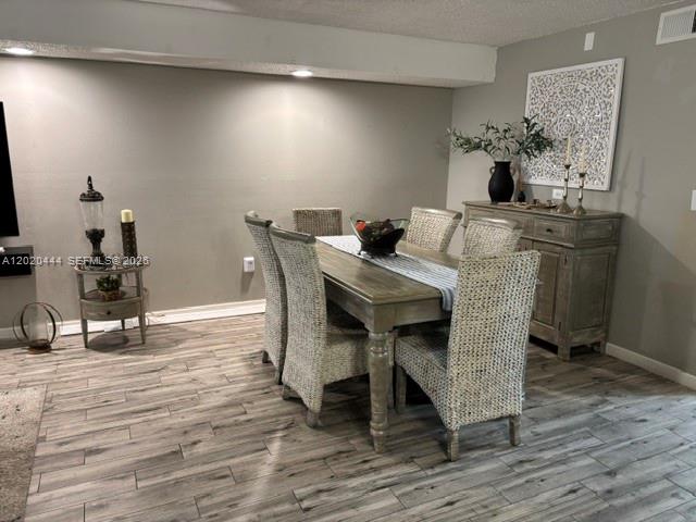 A dining room features a wooden table with woven chairs and a matching sideboard — 10621 SW 79th Ter, Miami FL 33173, MIAMI, FL