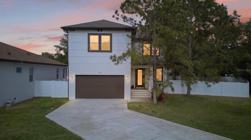 A two-story house with a white exterior, brown garage door, and a concrete driveway — 4102 S TRASK STREET, TAMPA, FL