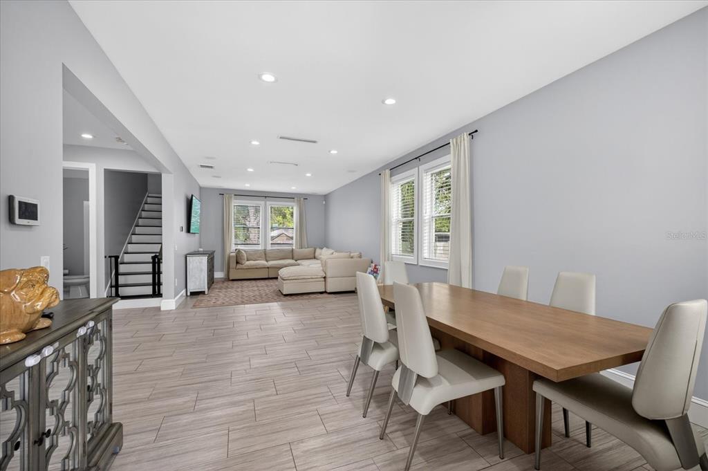 A dining area with a wooden table and chairs opens into a living room — 4102 S TRASK STREET, TAMPA, FL