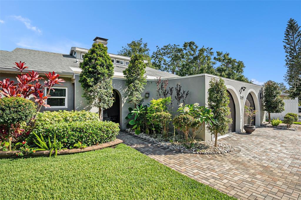 A single-story house with a gray exterior, arched entryways, and a paved driveway — 2134 SERPENTINE CIRCLE S, ST PETERSBURG, FL
