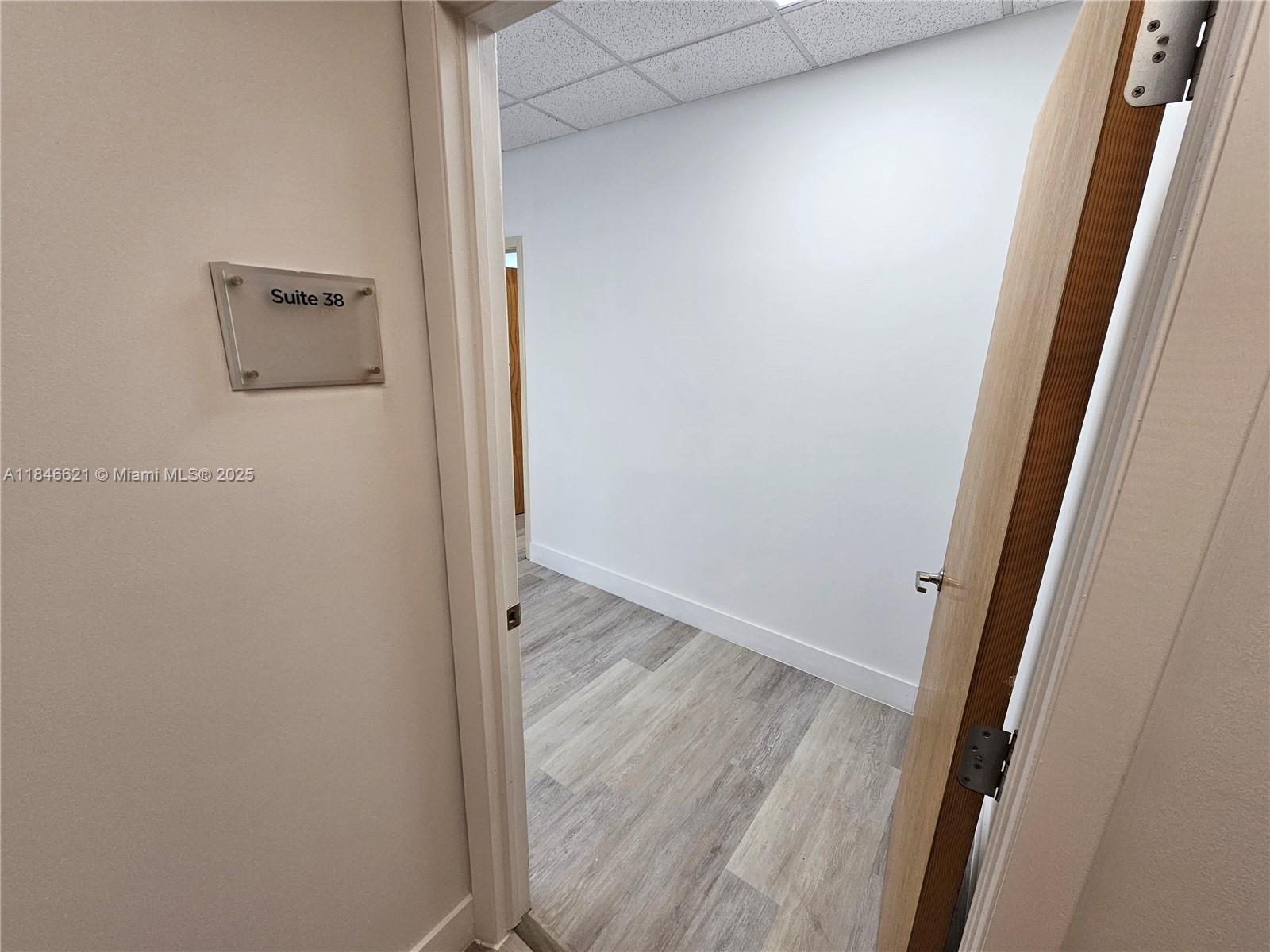 This office suite features light-colored walls, wood-look flooring, and a drop ceiling — 12550 Biscayne Blvd # 11, North Miami FL 33181, NORTH MIAMI, FL