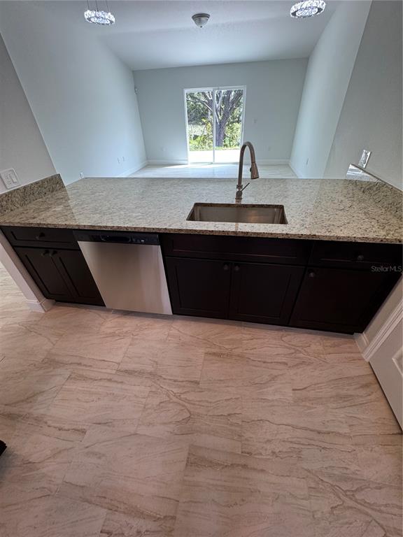 A kitchen island with a stainless steel sink and dishwasher sits on tiled flooring — 3148 N COVINGTON DRIVE, DELTONA, FL
