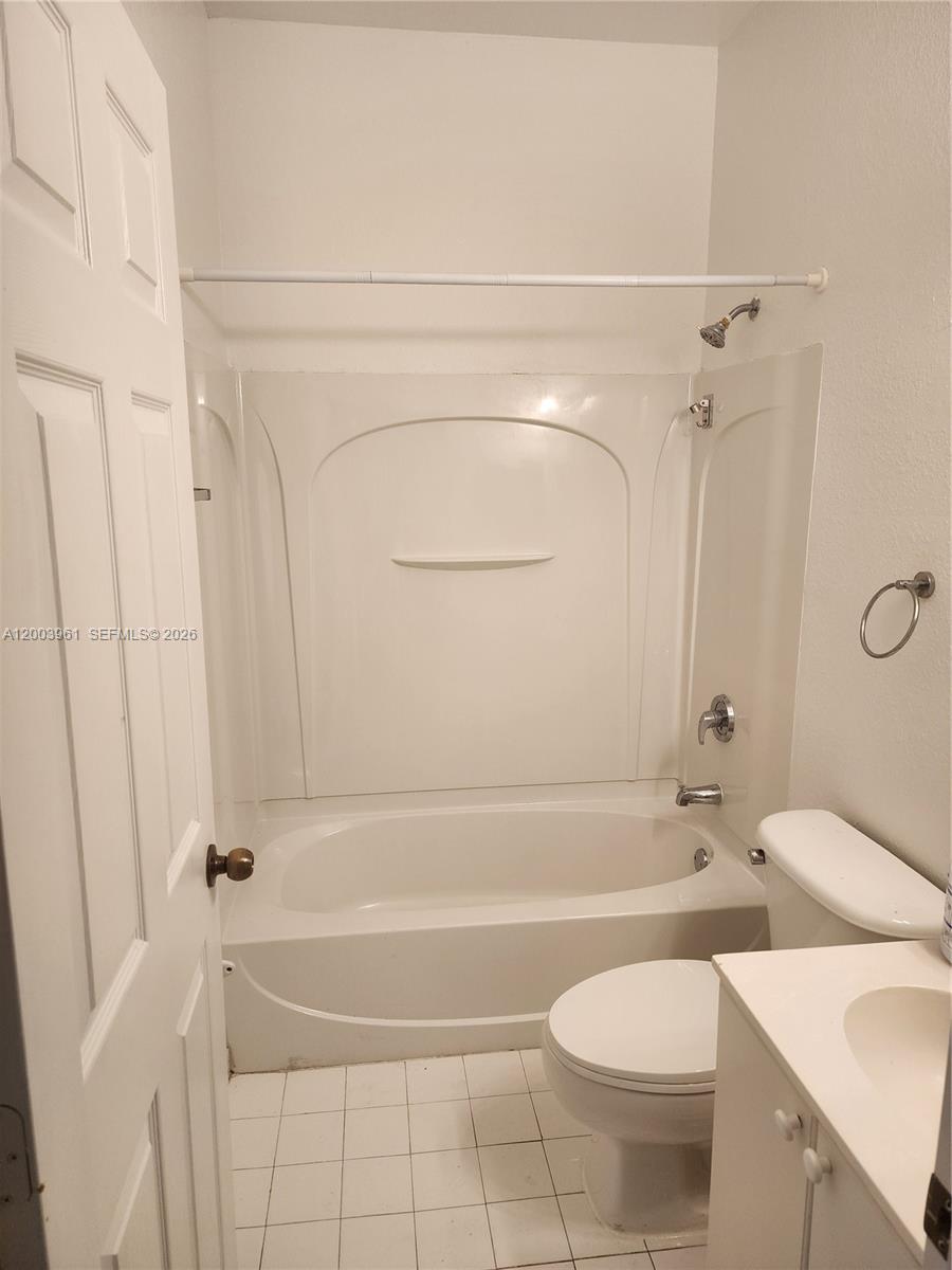 A bathroom features a white tub-shower combination, a toilet, and a vanity — 6972 NW 179th St # 4, Hialeah FL 33015, HIALEAH, FL