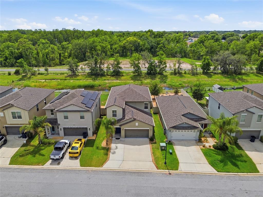 An aerial view shows a row of suburban houses with driveways facing a street — 13393 MARBLE SANDS COURT E, HUDSON, FL