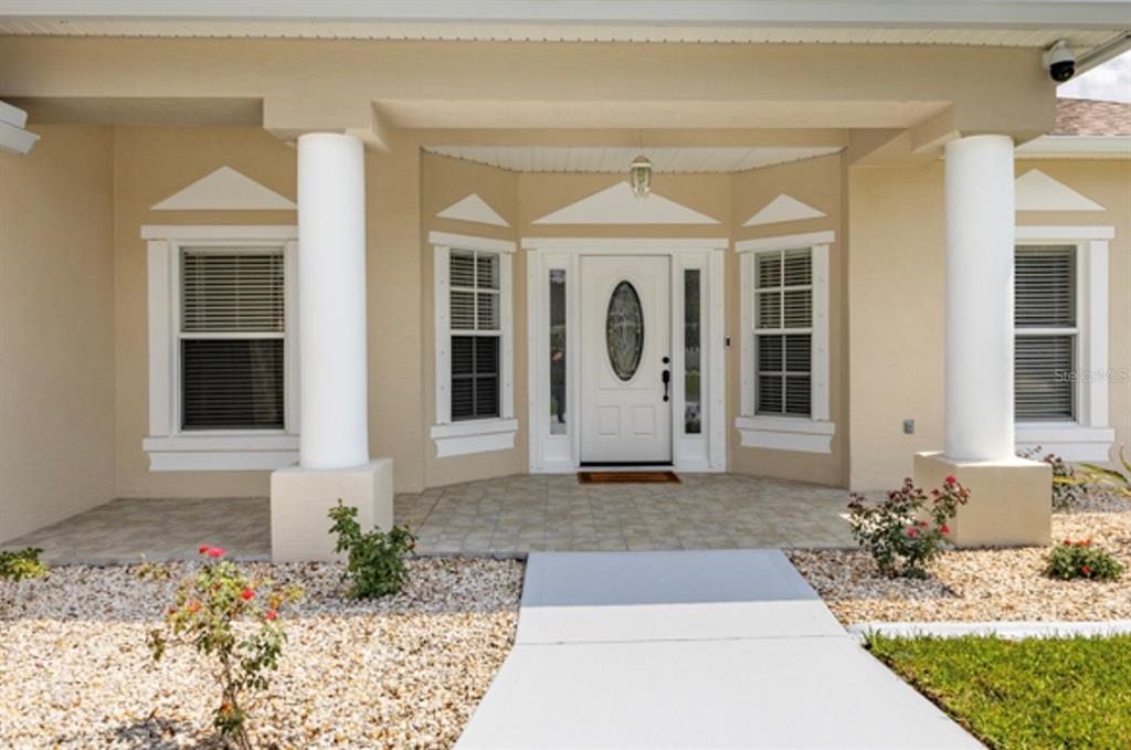 The front entrance of a house features a white door, two columns, and windows — 15 ROYAL PALM LANE, PALM COAST, FL