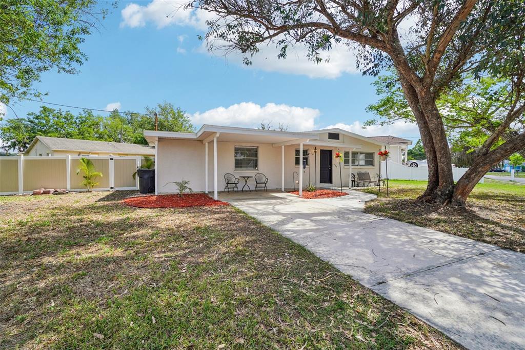 A single-story house with a concrete driveway, a covered carport, and a tan exterior — 541 FIREFLY LANE, APOLLO BEACH, FL