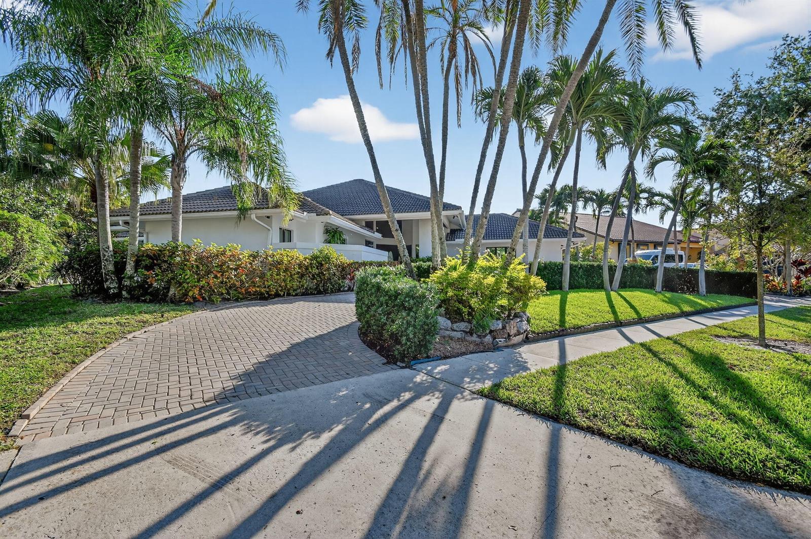A single-story house with a paved driveway, palm trees, and a manicured lawn — 2410 Embassy Drive, West Palm Beach FL 33401, WEST PALM BEACH, FL