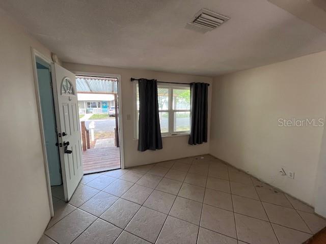 A room with tiled floors, a white door, and a window with dark curtains — 356 CLIFTON AVENUE, HOLLY HILL, FL