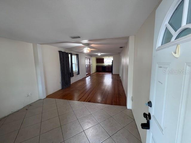 An interior view shows a tiled entryway transitioning into a living area with hardwood floors — 356 CLIFTON AVENUE, HOLLY HILL, FL