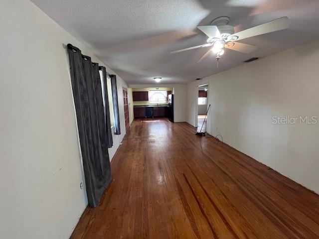 An interior view of a room with hardwood floors, a ceiling fan, and a kitchen — 356 CLIFTON AVENUE, HOLLY HILL, FL