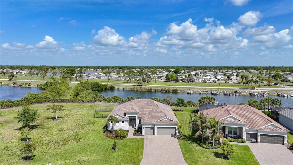An aerial view shows two suburban houses with tile roofs situated near a canal — 14332 PONCE DE LEON TRAIL, PORT CHARLOTTE, FL