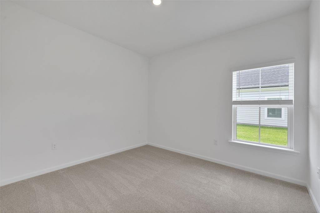 An empty bedroom with white walls, beige carpet, and a single window — 3890 HOLSTEIN WAY, GREEN COVE SPRINGS, FL