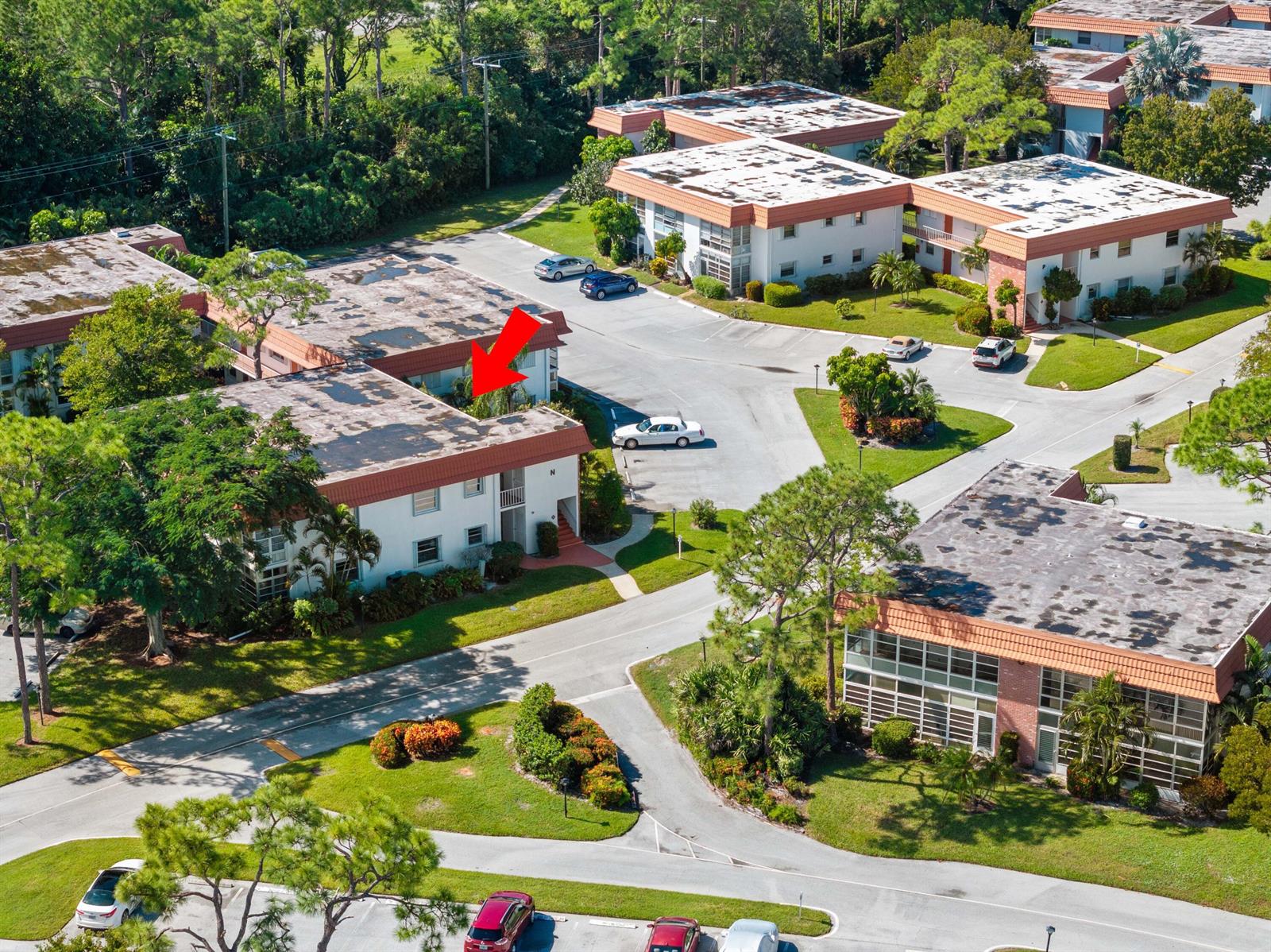 An aerial view shows a multi-story apartment complex with a red arrow pointing toward a unit — 2600 SE Ocean Boulevard # N14, Stuart FL 34996, STUART, FL