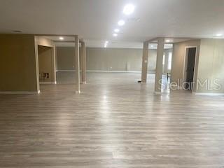 A large, open-concept room features light wood-look flooring, recessed lighting, and several support columns — 9200 66TH STREET N, PINELLAS PARK, FL