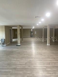 A large, open-concept room features light wood-look flooring, recessed lighting, and several support columns — 9200 66TH STREET N, PINELLAS PARK, FL