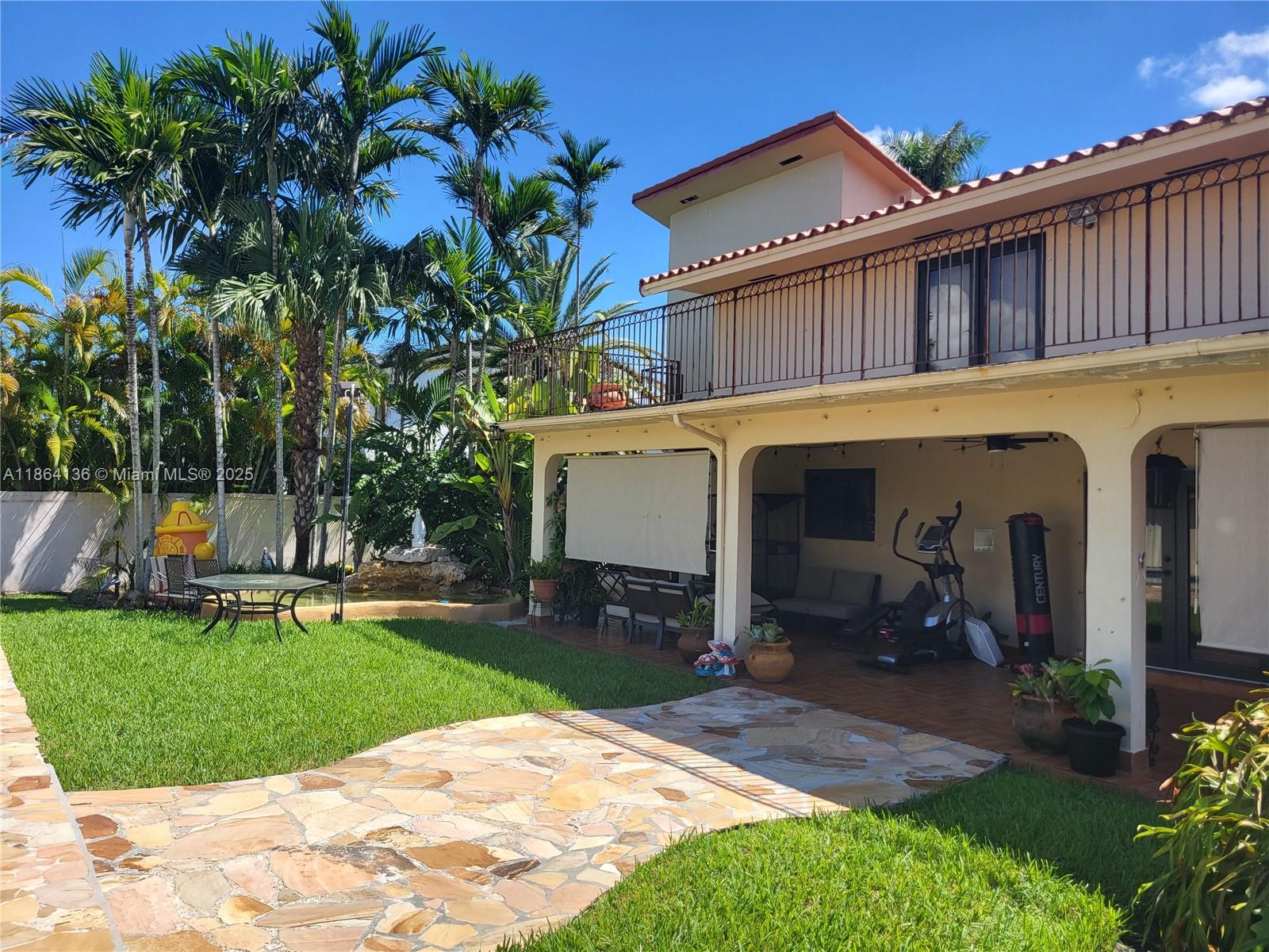 A two-story house with a covered patio, stone walkway, and palm trees in the backyard — 2930 SW 129 Ave, Miami FL 33175, MIAMI, FL