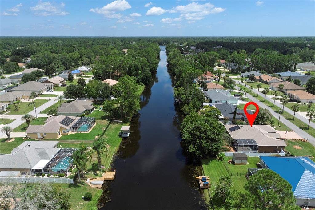 An aerial view shows a residential neighborhood with houses along a canal — 52 BUTTONWORTH DRIVE, PALM COAST, FL