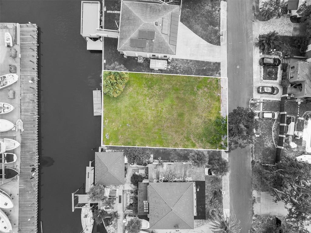 An aerial view shows a rectangular vacant lot situated between two houses and a canal — 274 LEXINGTON DRIVE, DAYTONA BEACH, FL