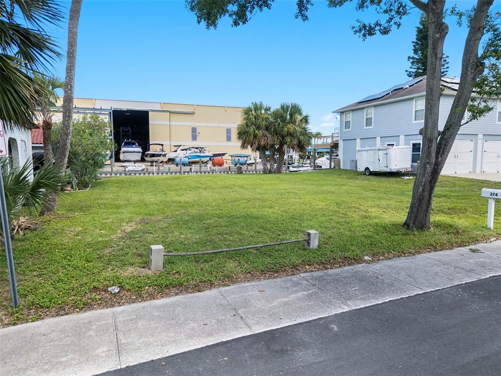 A vacant grassy lot sits between a light blue house and a large industrial building — 274 LEXINGTON DRIVE, DAYTONA BEACH, FL