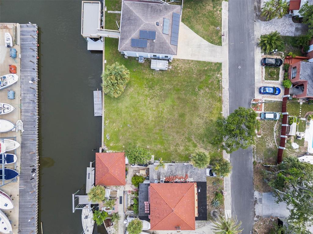 An aerial view shows a vacant waterfront lot situated between two houses along a canal — 274 LEXINGTON DRIVE, DAYTONA BEACH, FL