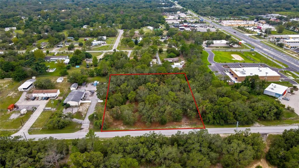 An aerial view shows a rectangular, tree-covered vacant lot outlined in red along a road — 0 OLD SHADY HILLS ROAD, SPRING HILL, FL