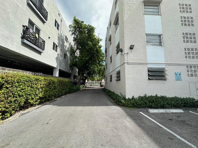 A narrow paved driveway runs between two multi-story apartment buildings with a tree in between — 1337 NW 1st St # 14, Miami FL 33125, MIAMI, FL