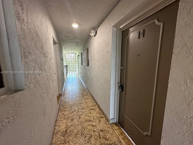 A hallway with textured walls, tiled floors, and a door marked with the number 14 — 1337 NW 1st St # 14, Miami FL 33125, MIAMI, FL