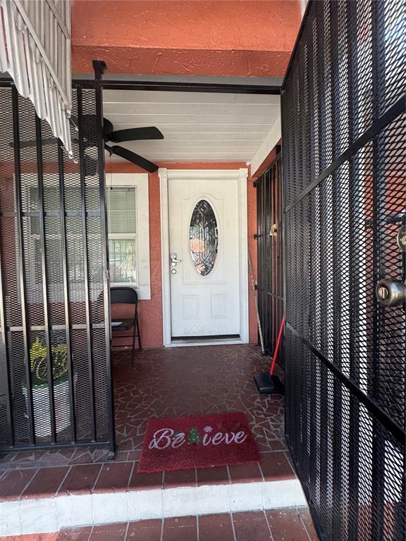 A covered porch features a white front door, metal security gates, and a red doormat — 2312 W LA SALLE STREET, TAMPA, FL