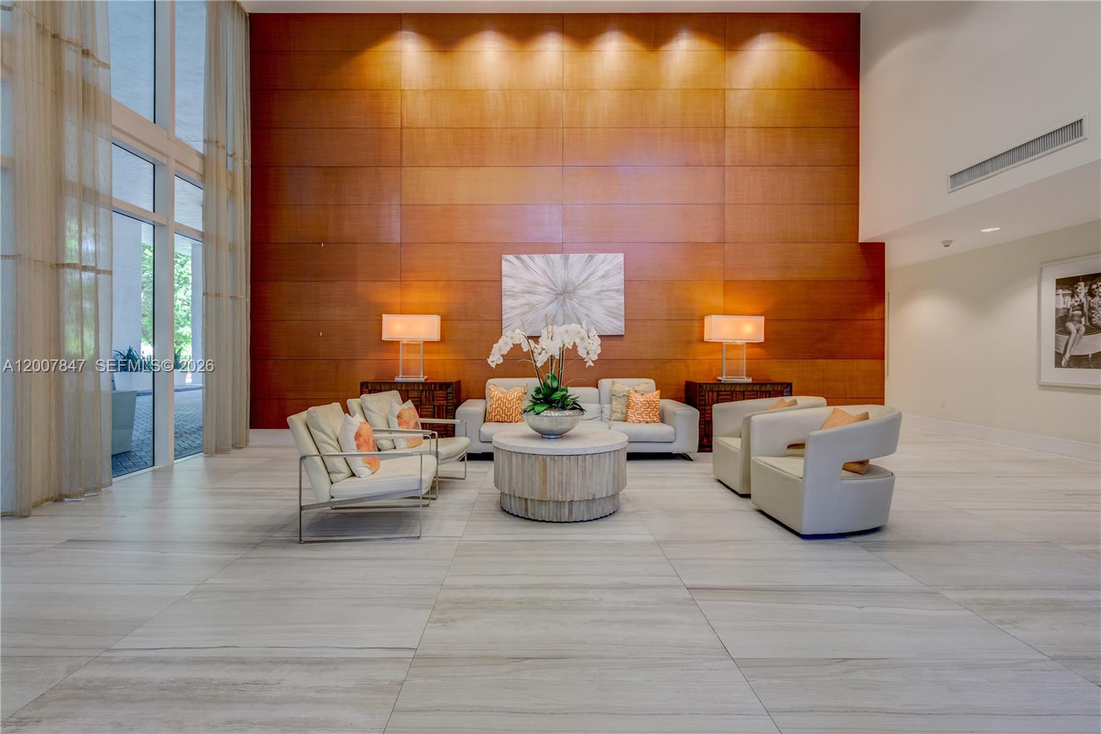 A modern lobby features a large wood-paneled wall, light-colored seating, and floor-to-ceiling windows — 1871 NW S River Dr # 802, Miami FL 33125, MIAMI, FL