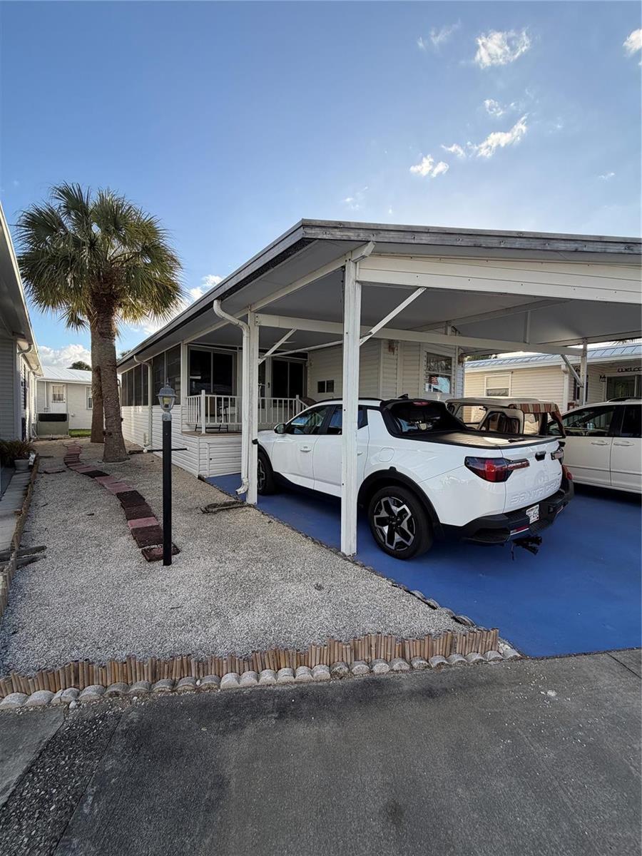 A white pickup truck is parked under a carport next to a manufactured home — 6444 SE 51st Lane, Okeechobee FL 34974, OKEECHOBEE, FL