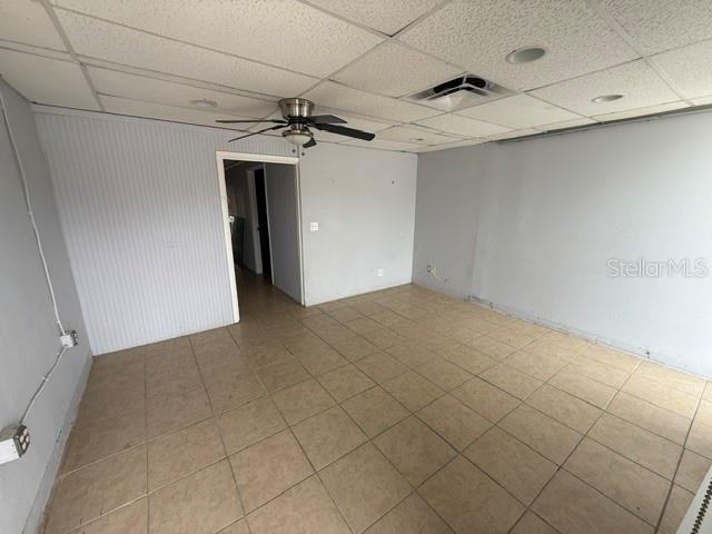 An empty room features light-colored tile flooring, gray walls, and a ceiling fan — 1444 GULF TO BAY BOULEVARD, CLEARWATER, FL