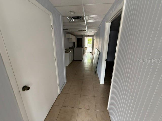 A hallway with tile flooring leads toward a kitchen area and an exterior doorway — 1444 GULF TO BAY BOULEVARD, CLEARWATER, FL